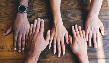 Diverse set of hands on a wooden background. 